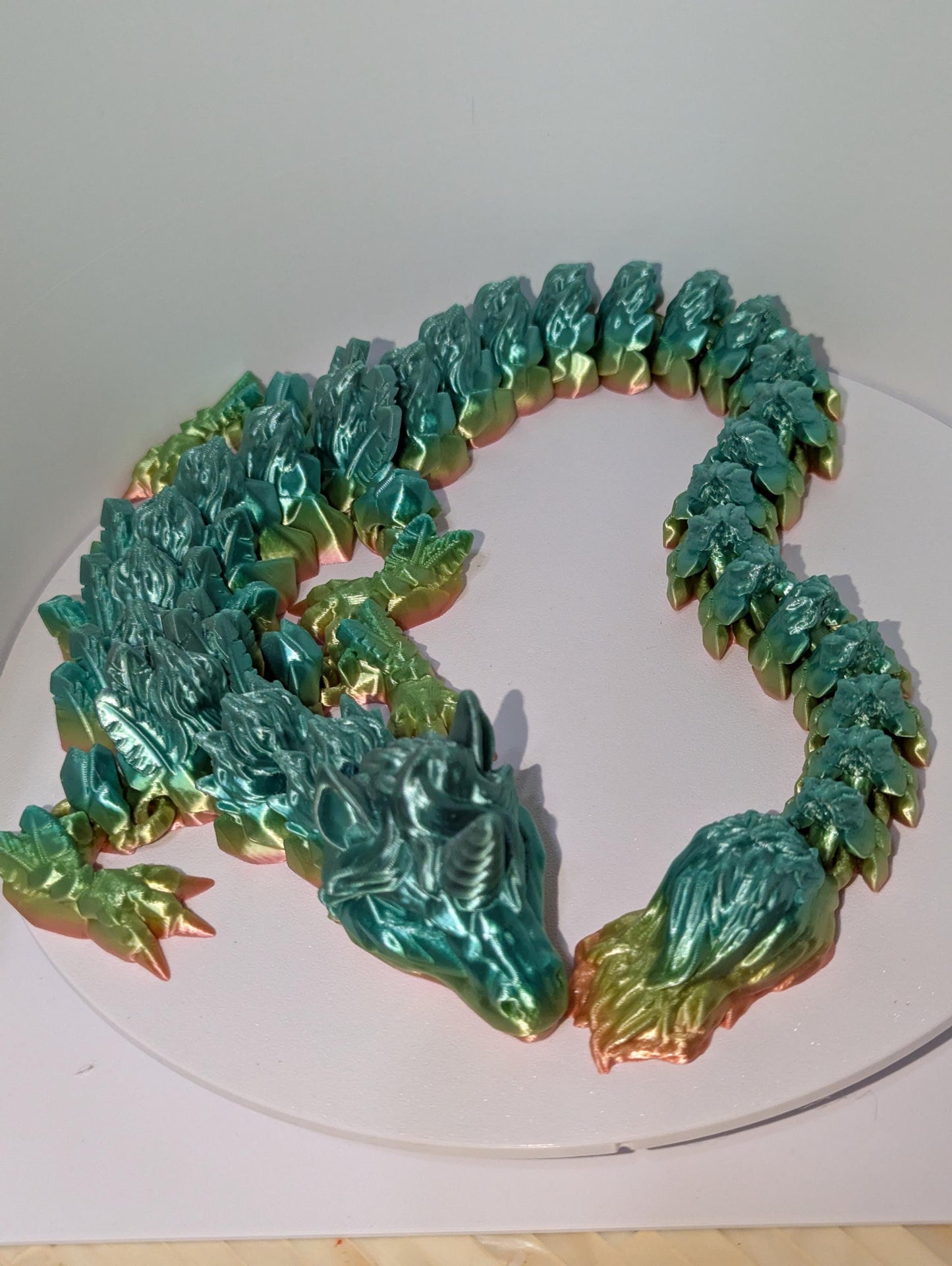 Front profile of this rainbow articulated unicorn dragon curled up.