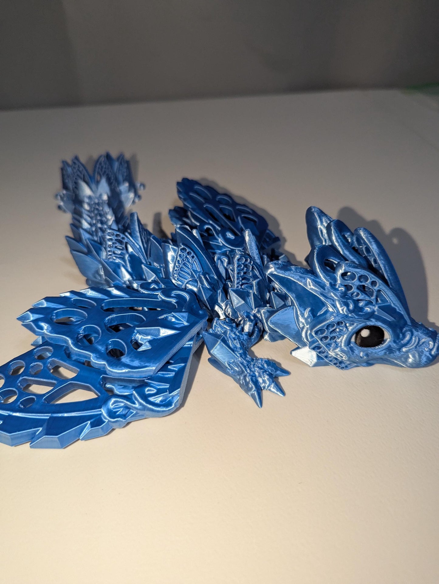 Side view of the silver/blue baby winged articulated dragon.