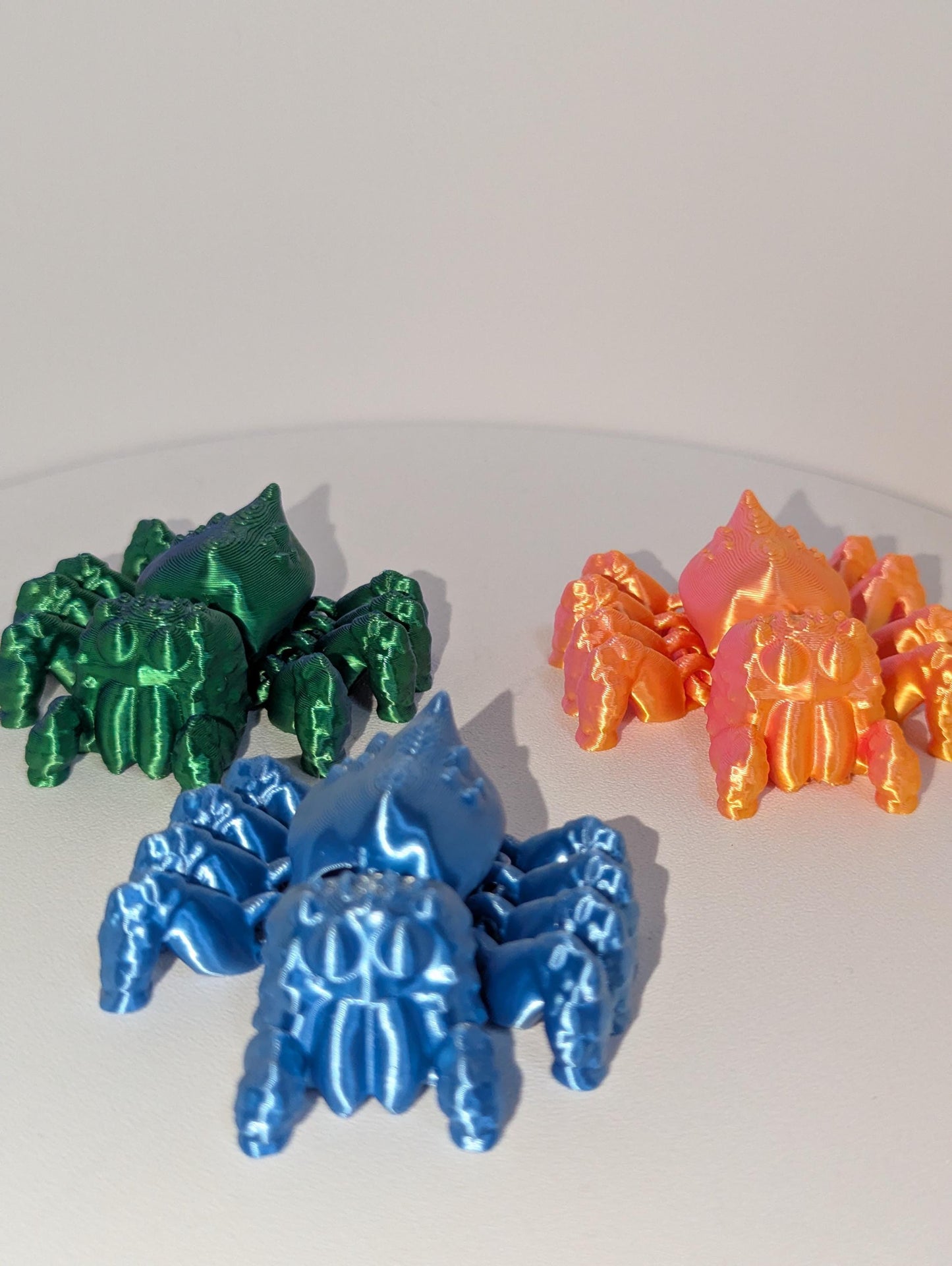 Cute Articulated Spiders previewing three in blue, orange, and green. forwarded facing