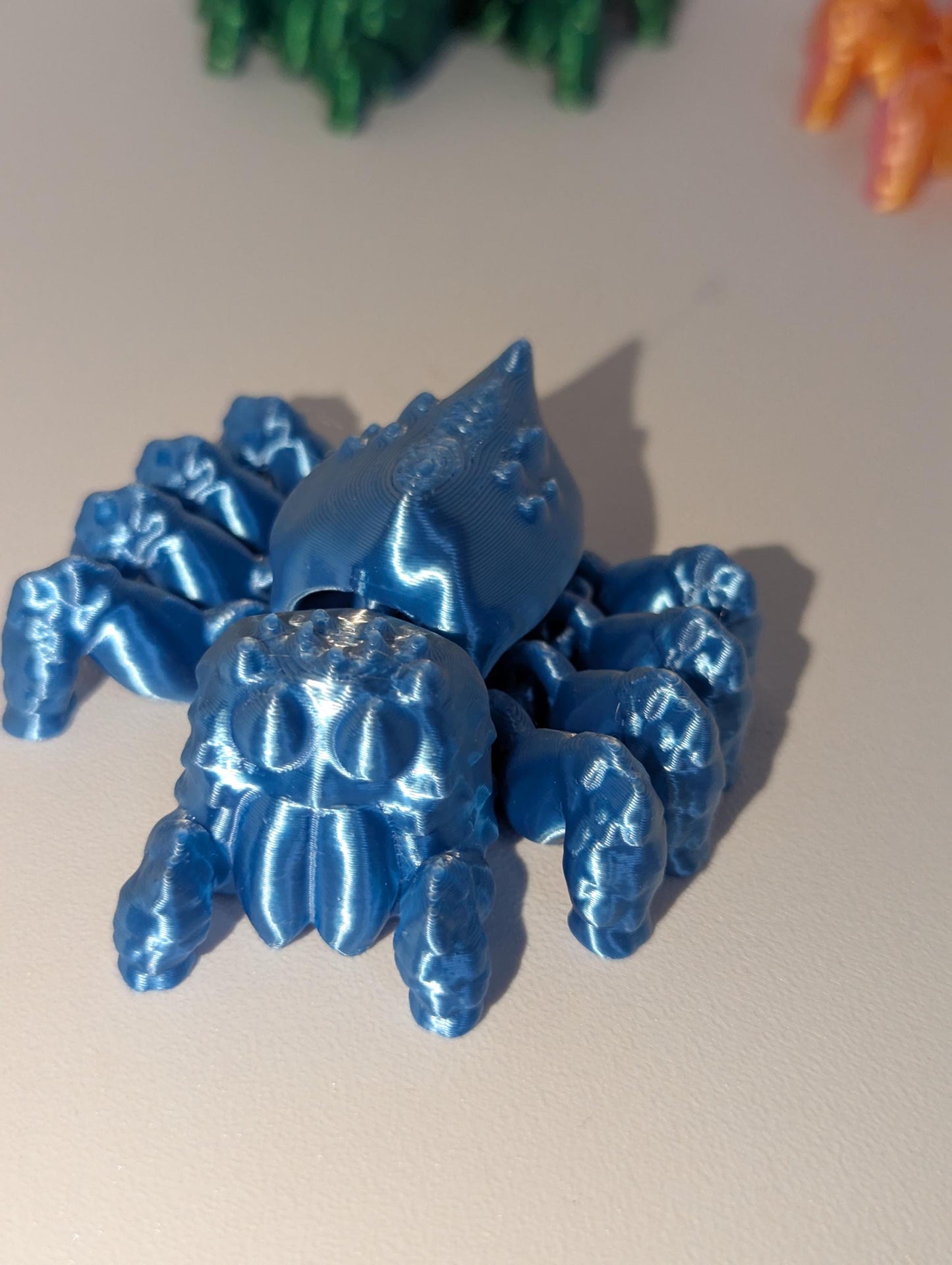 Up-close front view of the blue articulated spider.