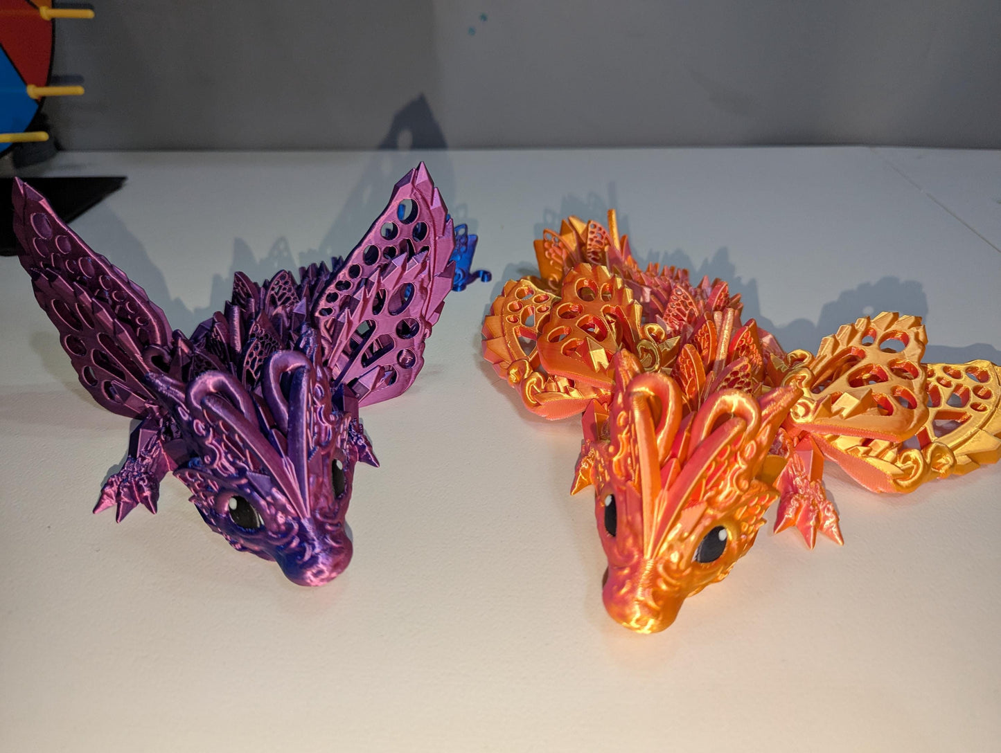up-close view of the orange/pink and purple/blue winged baby articulated dragon.