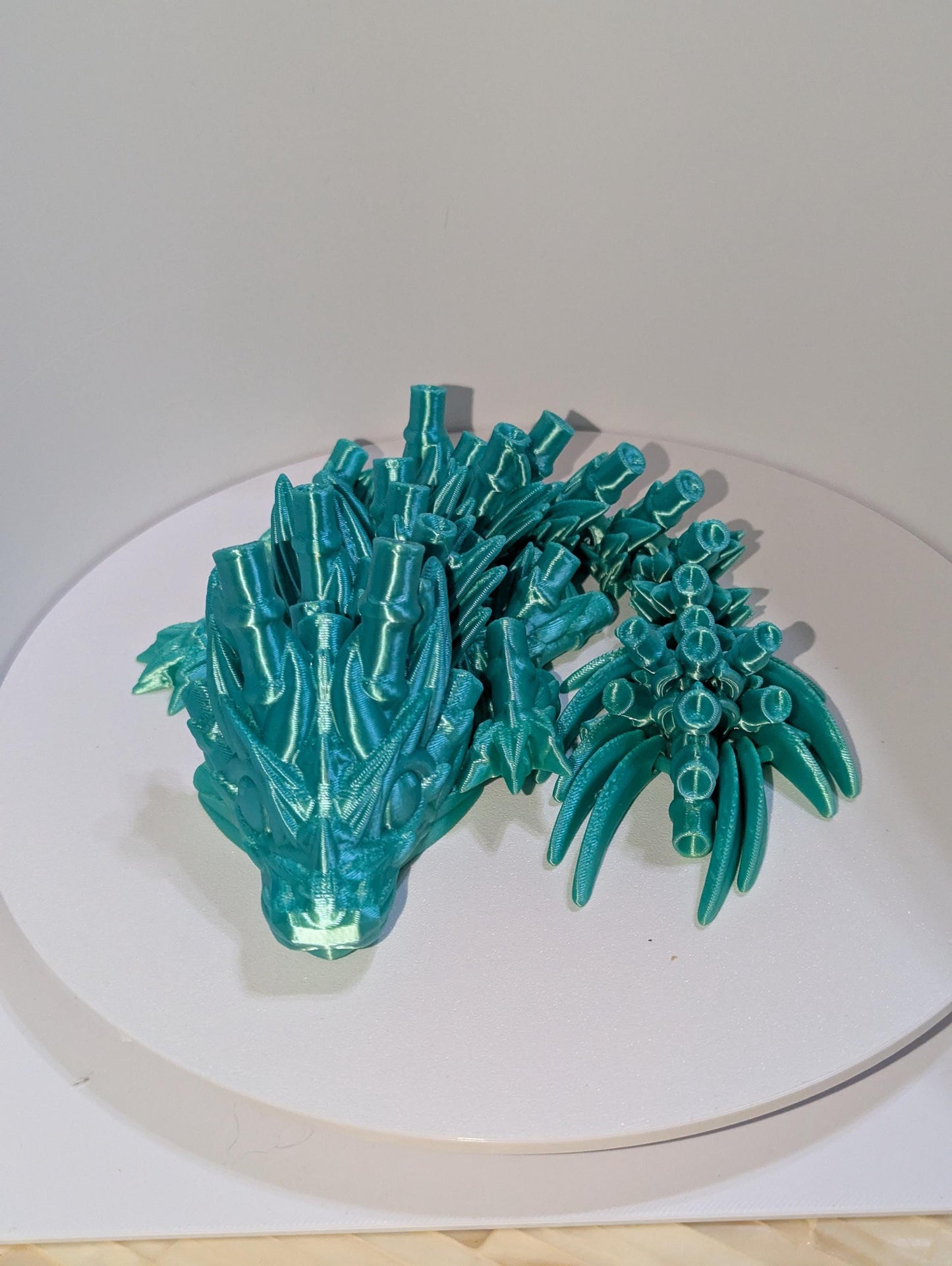 Curled up Green Translucent baby  Bamboo Articulated dragon. Front Profile