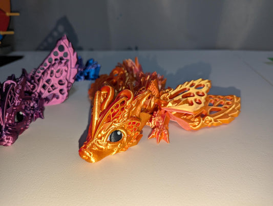 Side view of the orange/pink and purple/blue baby winged articulated dragon.